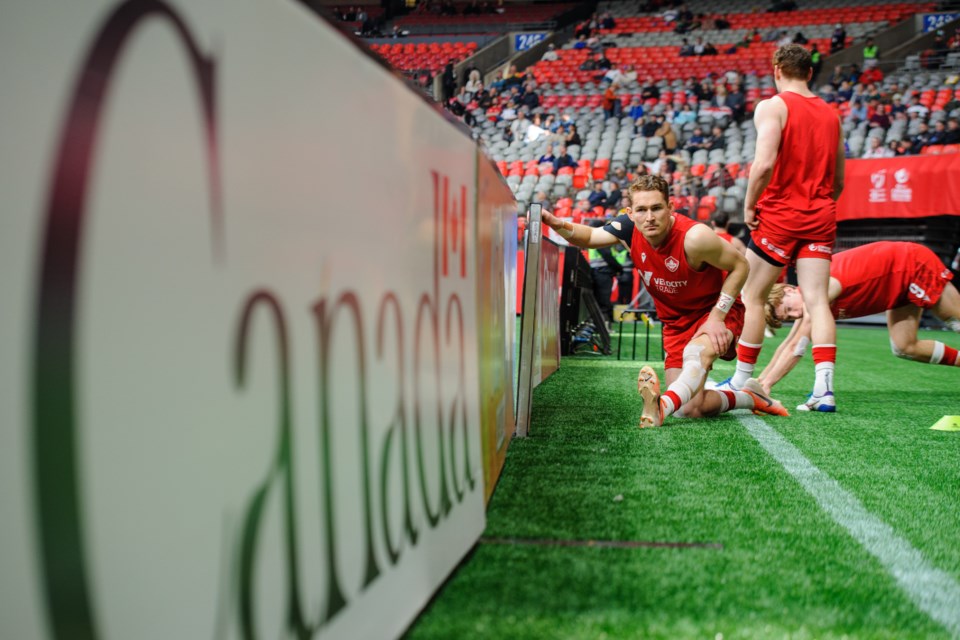 Cooper Coats from the Canadian senior men's rugby sevens team Stretches before a match at the Canada Sevens in Vancouver, B.C. on April 17, 2022