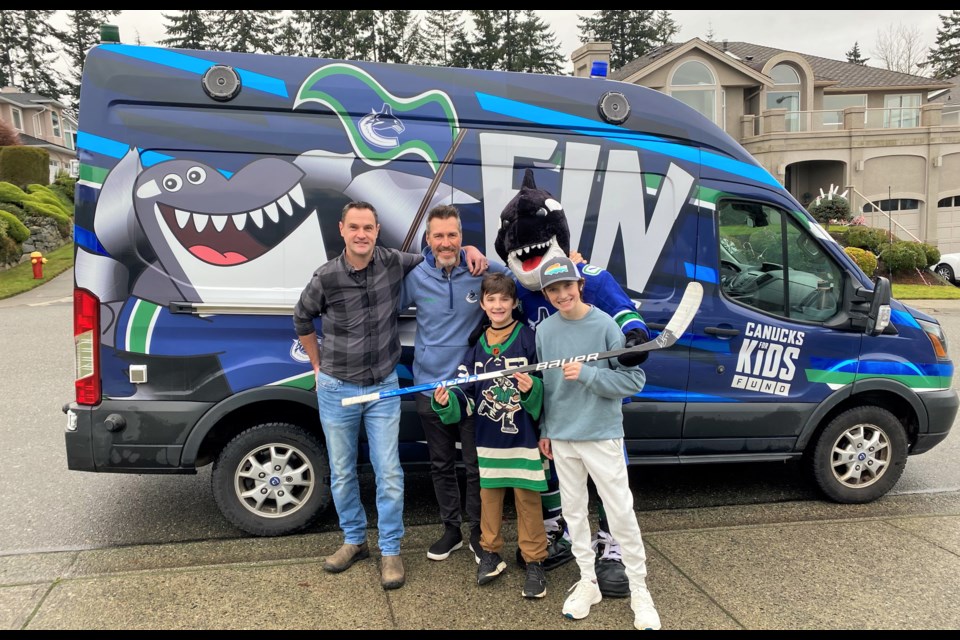 Kirk McLean and Fin took a photo with the brothers and their step-dad Mike when the Canucks delivered a new stick along with other swag.