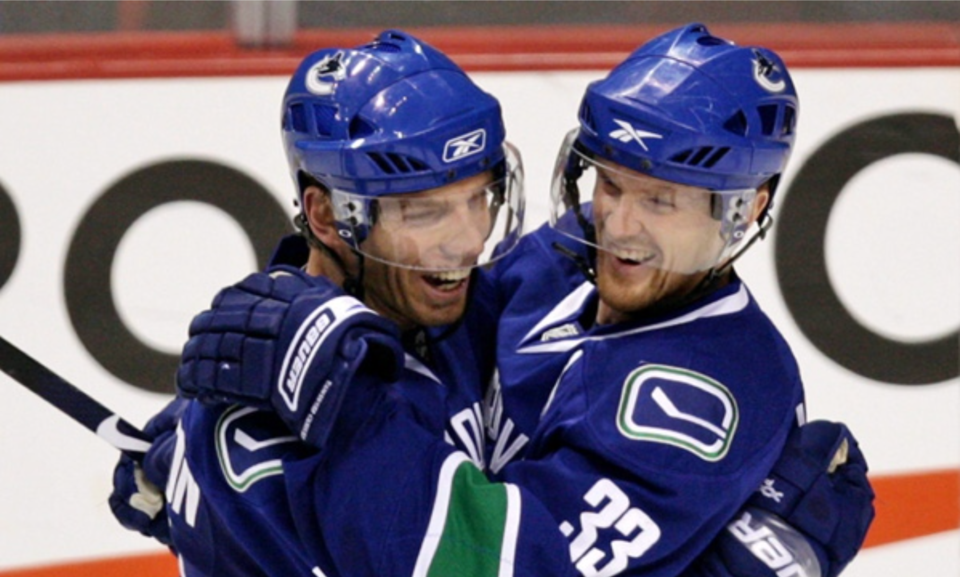 Mikael Samuelsson hugs Henrik Sedin