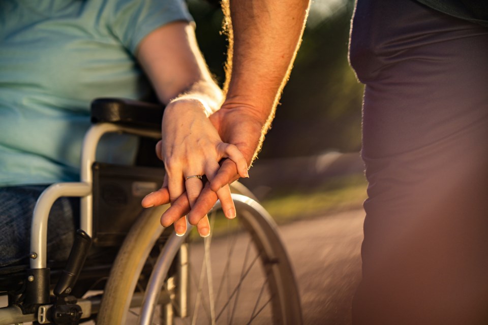 couple-holding-hands-wheelchair