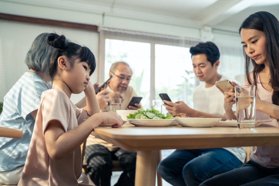 family-using-smartphones-dinner-table