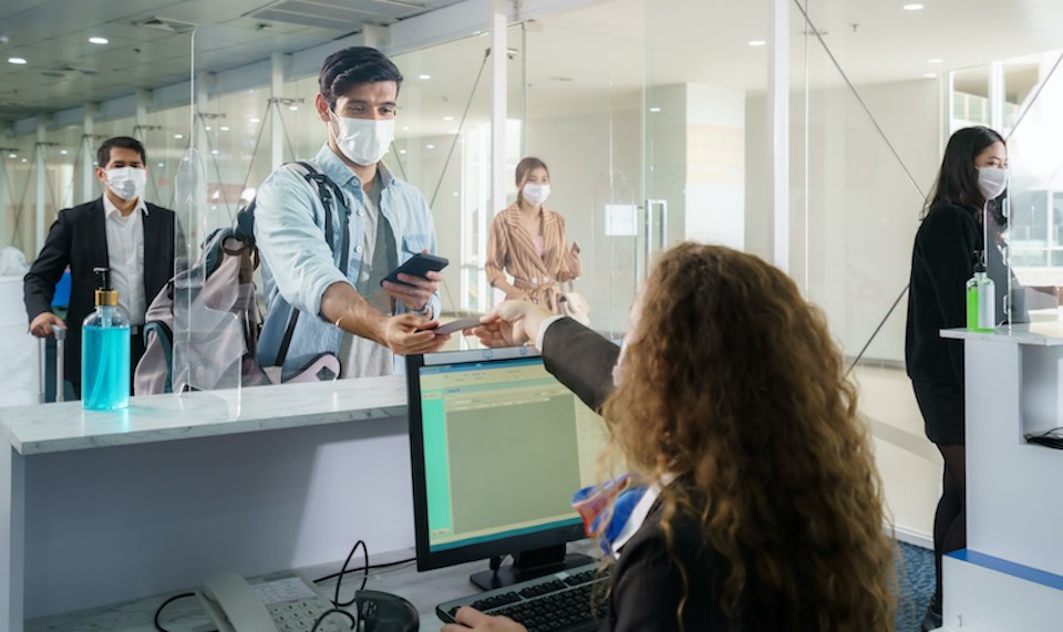 man-checking-in-airport-wearing-face-mask