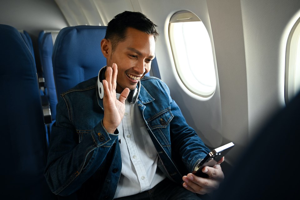 person-on-plane-smiling-phone