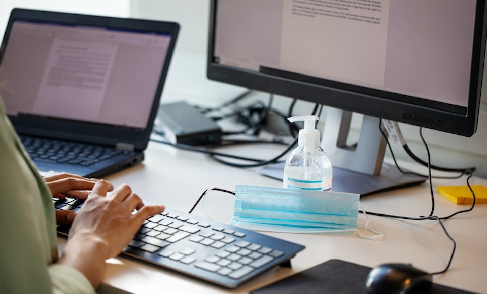 person-typing-letter-face-mask-sanitizer