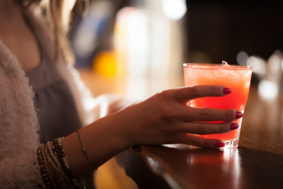 woman-holding-cocktail-close-bar
