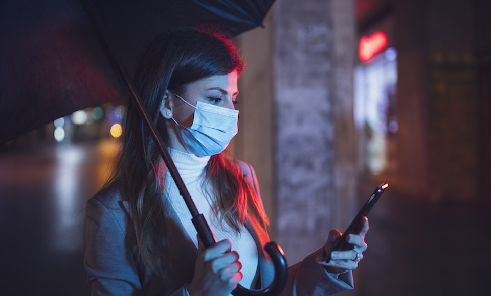 woman-looking-phone-umbrella-night