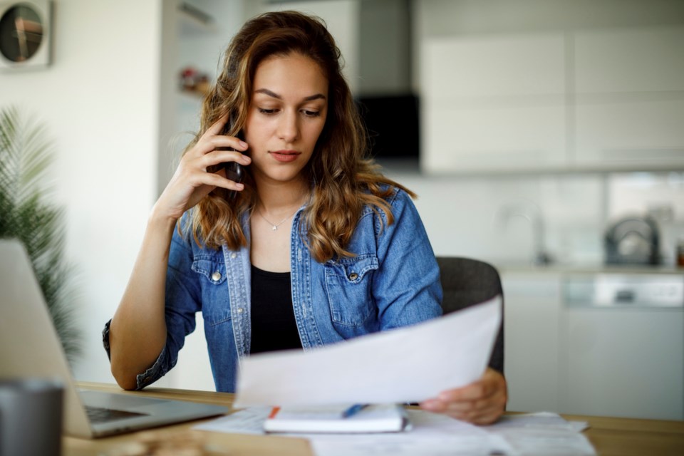 woman-phone-call-paperwork-bills-personal-finance