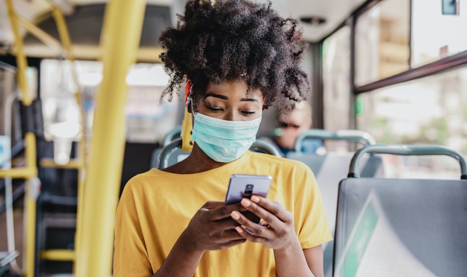 woman-wearing-mask-on-phone-on-bus