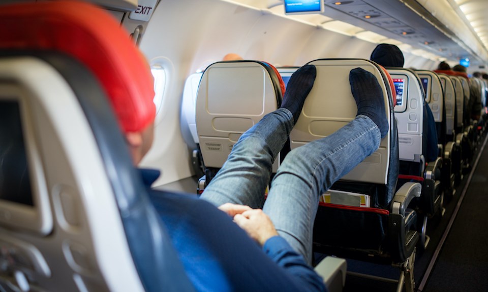 person-putting-feet-up-plane