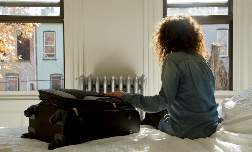 woman-traveller-on-bed-looking-out-window