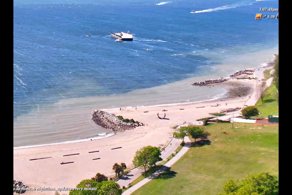 Footage from a webcam shows a barge drifting close to the shore in English Bay as a Coast Guard vessel tries to pull it away.