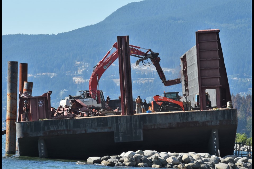 A giant jaw-like cutting tool is used to cut the walls on Vancouver's English Bay Barge