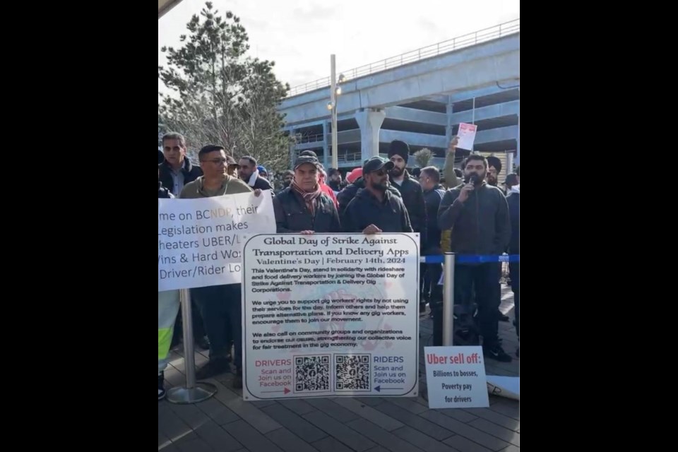 Signs read things like "Independence equals poverty," "Uber Sell Out," "Honk to Support," "Uber drivers on strike," and other messages with worker demands and support slogans.