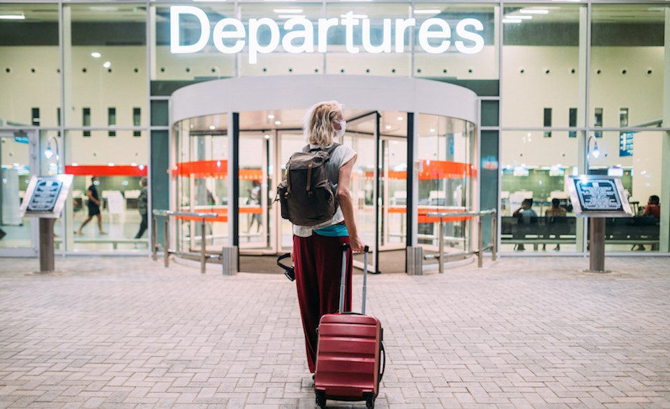 woman-outside-of-airport-departures-travel