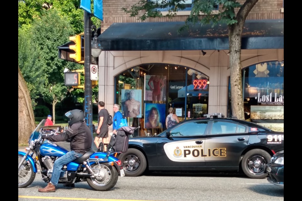 A reader submitted photos of VPD officers who they claim parked their car in a 'no stopping' space in order to visit a Tim Hortons across the street. Photo submitted