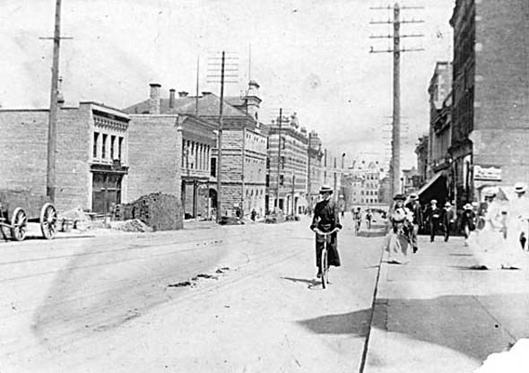 1900 - A woman rides a bicycles south along Granville Street.