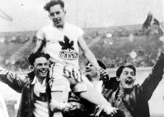  Canadian sprinter Percy Williams is carried on the shoulders of two men after winning the 200-metre race at the Olympic Games in Amsterdam, 1928. VPL 13295.