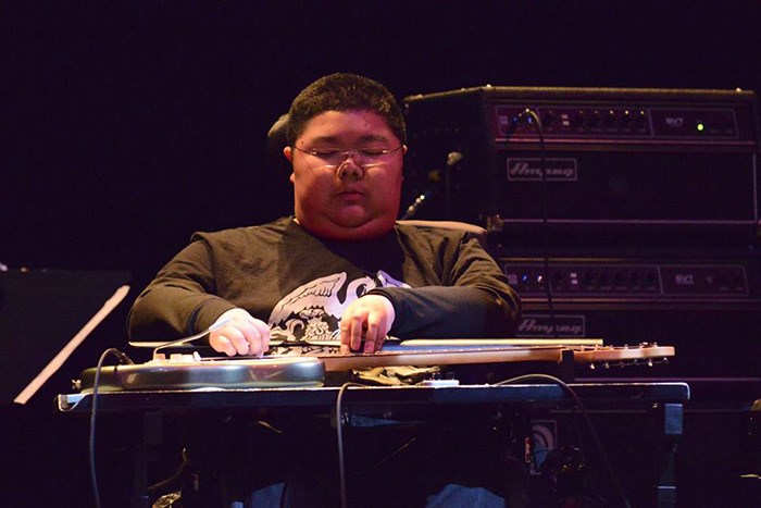  Richard Quan with his adapted electric guitar.