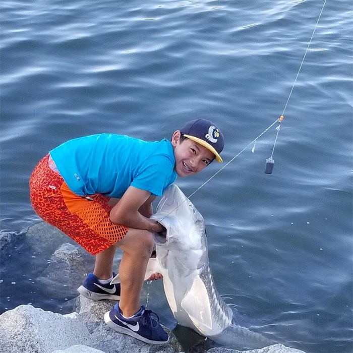  Josh Low hauls ashore his 200-pound, eight-foot sturgeon from the Fraser River. Photo submitted