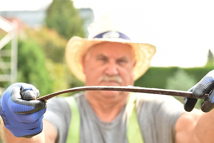  Roofer David Hodgson shows the flexibility of a boiled shingle. Photo Dan Toulgoet