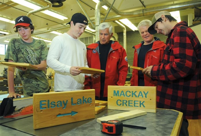  North Shore Rescue veterans Wally Kerchum and Peter Haigh oversee West Vancouver Secondary woodworking students, who have been making signs to help keep backcountry hikers on trail. photo Mike Wakefield, North Shore News