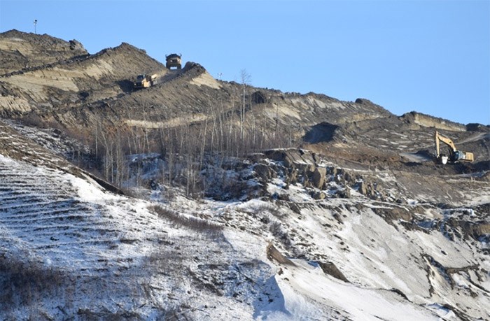  Trucks hauling earth on the north bank of the Site C dam earlier this year | Alaska Highway News