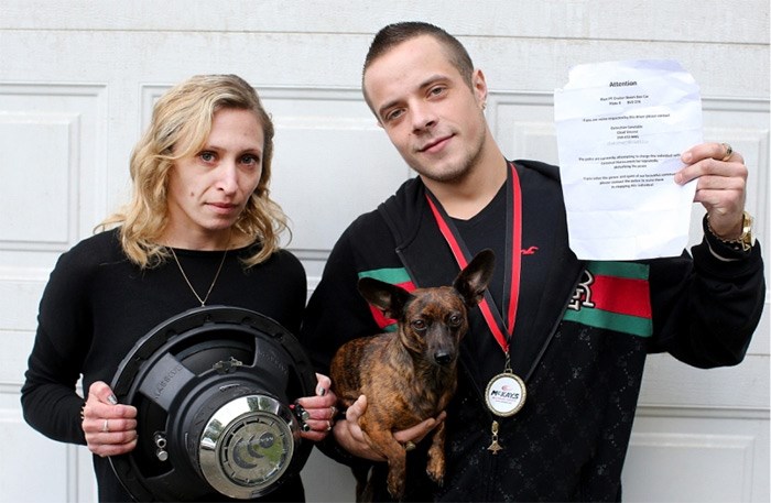  Dustin Hamilton, with his girlfriend, Katrina Jourdenais, and their dog, Luna, holds a sheet that was plastered all over the neighbourhood asking people to complain to police about the noise from his car stereo. The ban is 