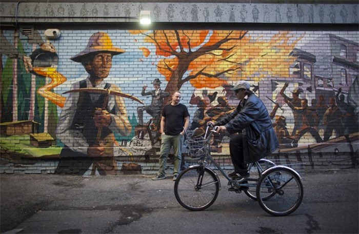  Pidgin restaurant owner Brandon Grossutti, back, poses for a photograph in front of a mural depicting the neighbourhood's history painted on the side of the restaurant in Vancouver, B.C., on Friday October 27, 2017. Entrepreneurs, developers and more affluent residents have moved into the Downtown Eastside at an accelerating rate in recent years, thanks in part to skyrocketing real estate prices elsewhere in the city, loosened zoning restrictions and the community's burgeoning appeal as a hip and happening place. THE CANADIAN PRESS/Darryl Dyck