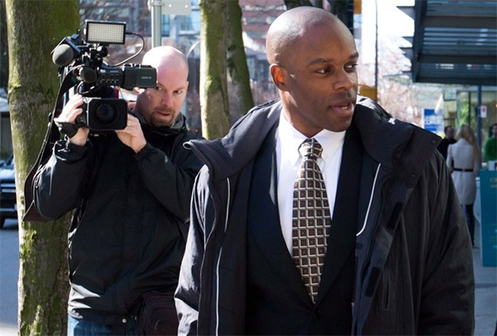  RCMP Const. Kwesi Millington, right, leaves court during a lunch break at his perjury trial in Vancouver, B.C., on Monday March 10, 2014. The Supreme Court of Canada has dismissed appeals from two men convicted of perjury in connection with a notorious Taser death at Vancouver's airport in 2007. THE CANADIAN PRESS/Darryl Dyck