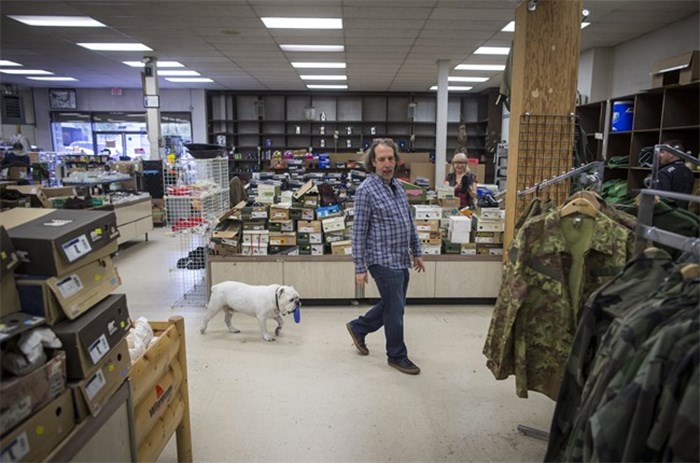  Jerry Wolfman, co-owner of the outdoor store Three Vets, is followed by his rescue dog Suge White while walking through the store, in Vancouver, B.C., on Tuesday October 31, 2017. Wolfman is closing his family's business, Three Vets, after 70 years in business selling outdoor gear. THE CANADIAN PRESS/Darryl Dyck