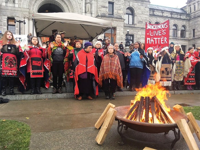  First Nations demonstrators gather around a fire at the B.C. legislature on Thursday, calling for an end to open-net fish farms. They drew about 200 supporters to their cause.   Photograph By Amy Smart