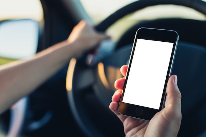  Driving with smartphone/Shutterstock