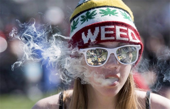  A woman exhales while smoking a joint during the annual 420 marijuana rally on Parliament hill on Wednesday, April 20, 2016 in Ottawa. THE CANADIAN PRESS/Justin Tang