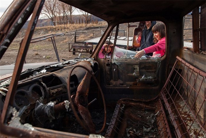  Tacheena Sutherland, 8, left, watches Nevaeh Porter, 9, look at the burned out truck at her grandparents' home in in Ashcroft, B.C., on Monday November 27, 2017. Little remains of the wreckage from Angie Thorne's home after a wildfire tore through her reserve in central British Columbia earlier this year. The blackened concrete, twisted metal chairs and seared welcome sign have all been removed, replaced with gravel backfill. 