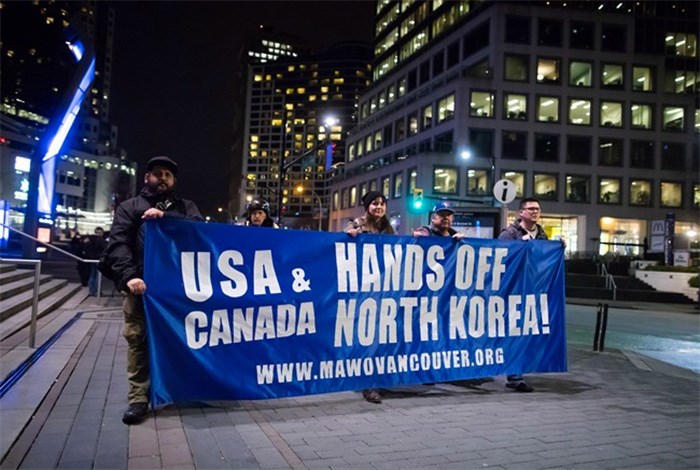  Protesters carry a banner while marching outside the site of a summit on North Korea being hosted by Canada and the U.S., in Vancouver, B.C., on Monday January 15, 2018. Foreign ministers from 20 countries are meeting Tuesday to discuss security and stability on the Korean Peninsula. THE CANADIAN PRESS/Darryl Dyck