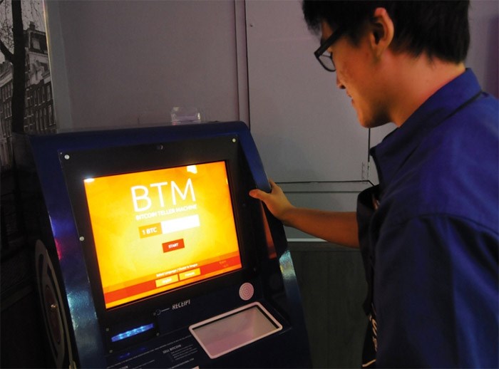  A customer uses a bitcoin terminal at Waves Coffee Shop on Lonsdale Avenue. Mike Wakefield photo