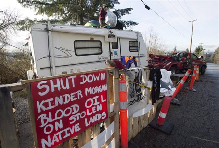  A protester who goes by the name Uni stands on top of a trailer outside the main gates of Kinder Morgan in Burnaby, B.C., Wednesday, Jan. 10, 2018. Municipalities and residents in British Columbia are set to argue that the proposed route of the Trans Mountain pipeline expansion would damage sensitive ecosystems, harm public parks and trails and adversely impact homeowners.THE CANADIAN PRESS/Jonathan Hayward