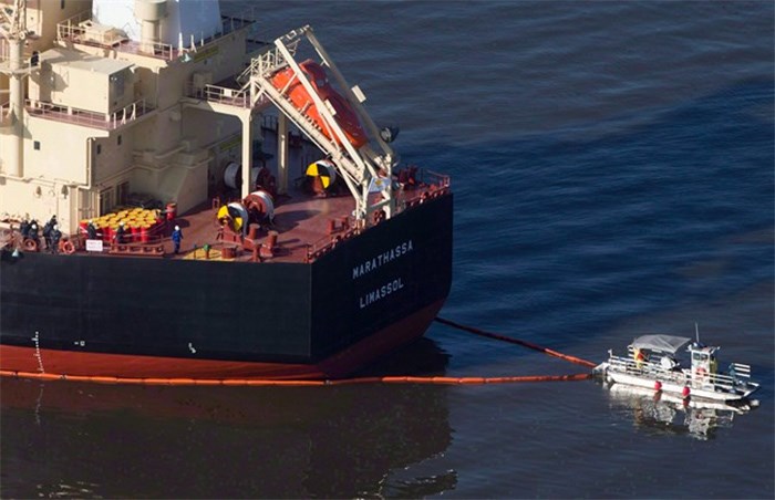  A spill response boat secures a boom around the bulk carrier cargo ship MV Marathassa after a bunker fuel spill on Burrard Inlet in Vancouver, B.C., on April 9, 2015. A trial for a vessel and a company that were charged after thousands of litres of bunker fuel spilled off British Columbia's coast nearly three years ago began in provincial court today without one defendant attending the court hearing. THE CANADIAN PRESS/Darryl Dyck