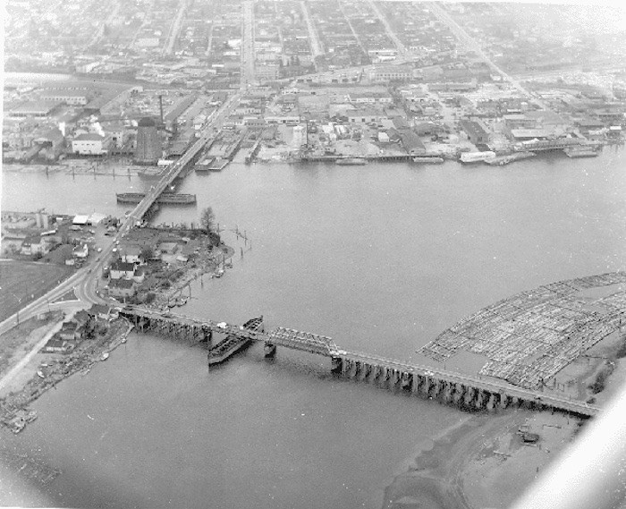  The bridge on the left is the Marpole Bridge, joining Marpole in Vancouver with Sea Island. The Eburne bridge at right joins Sea Island to Lulu Island, which is Richmond. You can see the Eburne Sawmill just to the left of the northern point of the Marpole Bridge. This photo is from 1954; by 1957 the Oak Street Bridge was opened and the Marpole Bridge dismantled. The Arthur Laing Bridge follows the same span currently. (City of Richmond Archives, Photograph #1984 17 21)