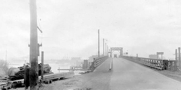  A vehicle heading south from Point Grey, Vancouver (now Marpole) to Sea Island, Richmond via the Marpole Bridge. The sign reads Fraser River North Arm. In the left on the horizon is the Eburne Bridge, connecting Sea Island's Eburne community with Lulu Island, Richmond. (Photo: Vancouver Archives)