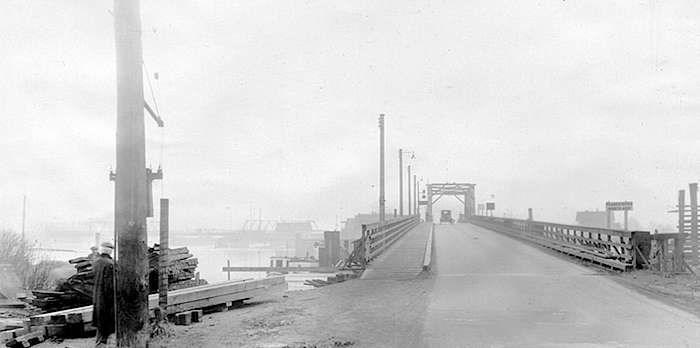  A vehicle heading south from Point Grey, 鶹ýӳ(now Marpole) to Sea Island, Richmond via the Marpole Bridge. The sign reads Fraser River North Arm. In the left on the horizon is the Eburne Bridge, connecting Sea Island's Eburne community with Lulu Island, Richmond. (Photo: 鶹ýӳArchives)