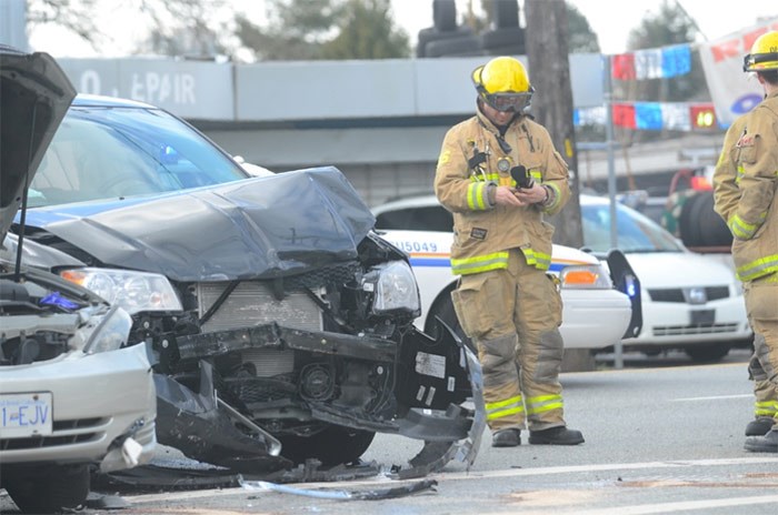  A Burnaby firefighter stands by a smashed, unmarked Vancouver Police Department vehicle after it collided with car occupied by a grandmother and her granddaughter Tuesday.