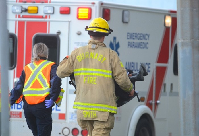  A Burnaby firefighter carries a young girl to a waiting ambulance in her car seat after a collision with an unmarked Vancouver Police Department vehicle in Burnaby Tuesday.