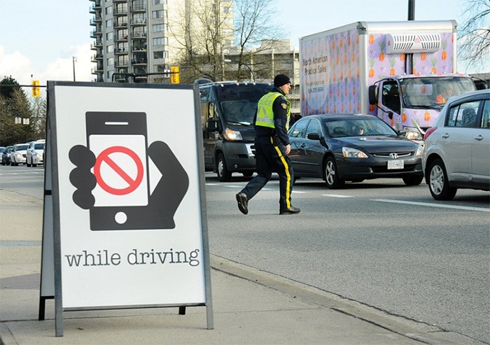  A North Vancouver RCMP member prepares to issue a ticket Tuesday afternoon during a distracted driving enforcement blitz at three strategic locations on the North Shore. photo Cindy Goodman, North Shore News