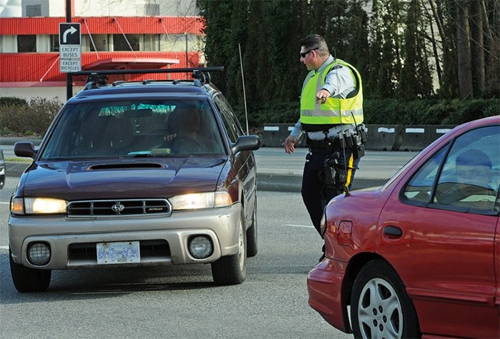  A North Vancouver RCMP member prepares to issue a ticket Tuesday afternoon during a distracted driving enforcement blitz at three strategic locations on the North Shore. photo Cindy Goodman, North Shore News