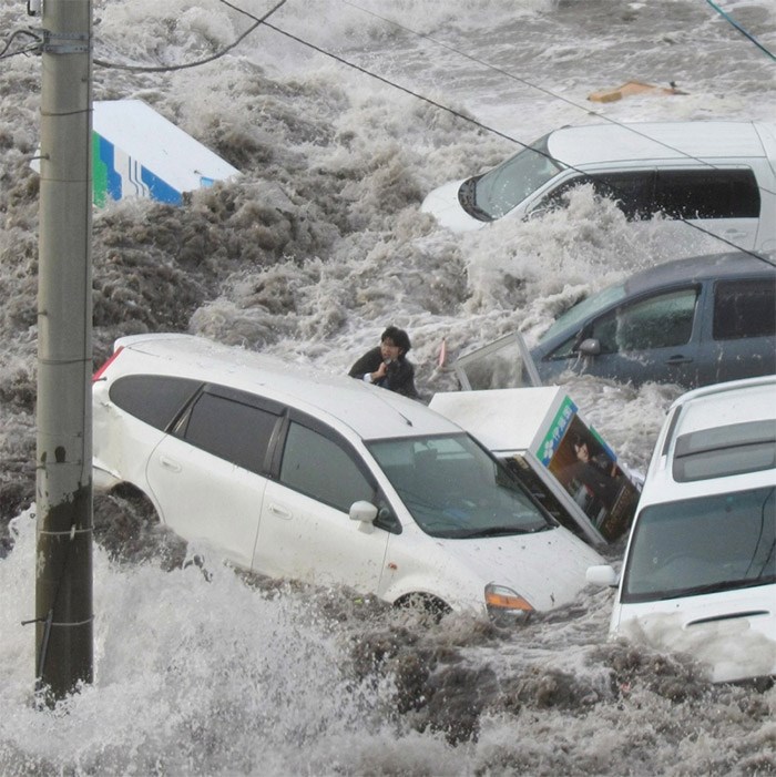  March 11, 2011: A reporter with the Iwate Tokai newspaper is swept by a surging tsunami at the port city of Kamaishi, in northeastern Japan, after a magnitude-9.1 earthquake. Toya Chiba, who was shooting photos when the tsunami struck him, survived and found himself only suffering scratches and bruises after being swept away for about 30 metres.