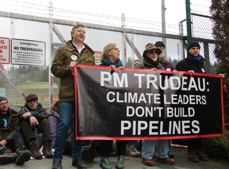  Kennedy Stewart and Elizabeth May hold a banner, blocking the entrance to the Kinder Morgan facility.