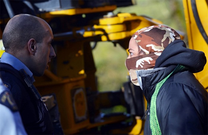  A female pipeline protester confronts police at an incident on March 16 that saw another protester chain herself to a work truck outside of Kinder Morgan's Burnaby Mountain tank farm.