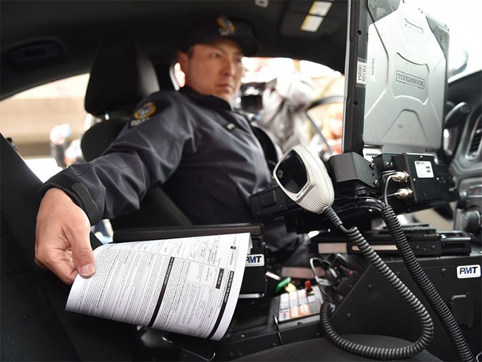  Vancouver police Const. John Kim demonstrates the new electronic ticketing system. Photo Dan Toulgoet