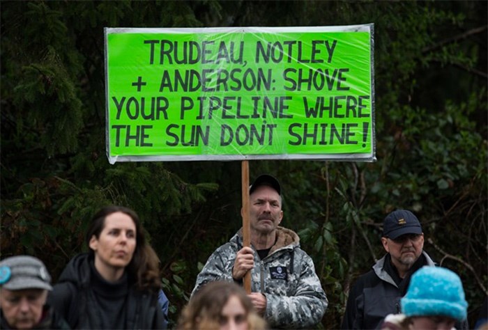  A man holds a sign while listening as other protesters opposed to the Kinder Morgan Trans Mountain pipeline extension defy a court order and block an entrance to the company's property, in Burnaby, B.C., on Saturday April 7, 2018. The pipeline is set to increase the capacity of oil products flowing from Alberta to the B.C. coast to 890,000 barrels from 300,000 barrels. THE CANADIAN PRESS/Darryl Dyck